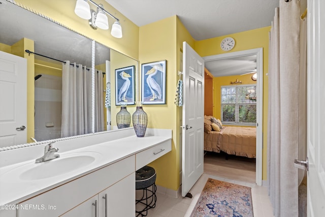 ensuite bathroom with baseboards, ensuite bath, tile patterned floors, curtained shower, and vanity