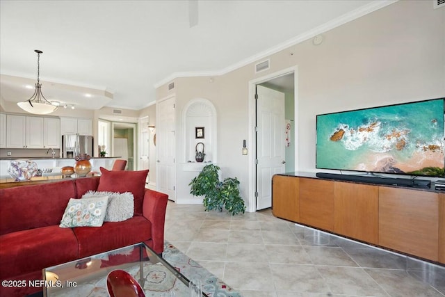 living room featuring light tile patterned floors, visible vents, and crown molding