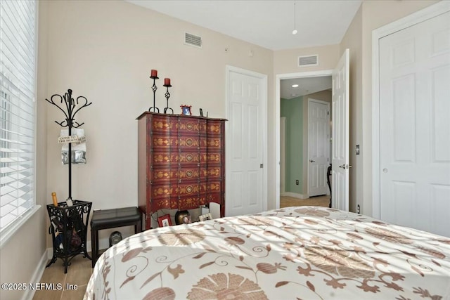 bedroom featuring baseboards and visible vents