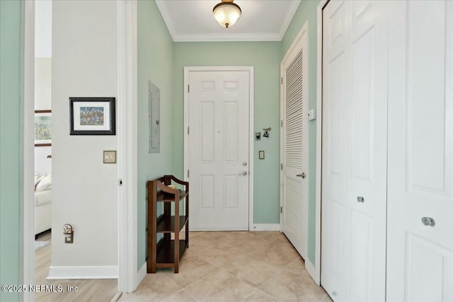 foyer entrance featuring crown molding, light tile patterned floors, and baseboards