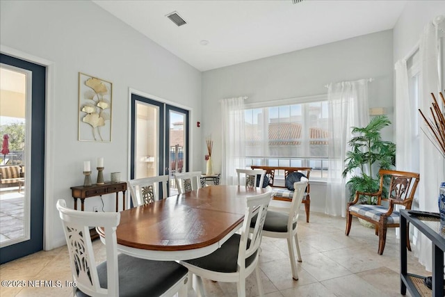 dining space with light tile patterned floors and visible vents