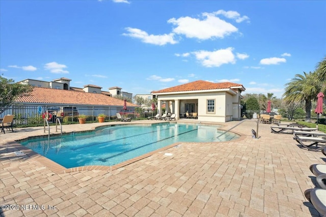 pool featuring a patio area, an outbuilding, and fence