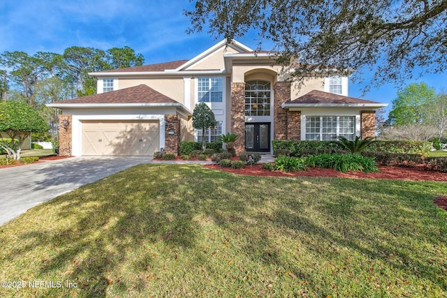 traditional home with an attached garage, brick siding, concrete driveway, stucco siding, and a front lawn