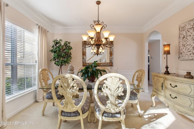 dining space with crown molding, arched walkways, light carpet, and a notable chandelier