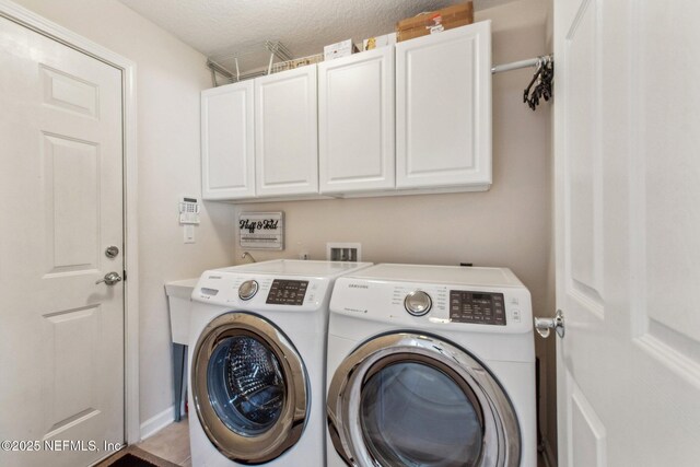 laundry area featuring washer and dryer, cabinet space, and baseboards