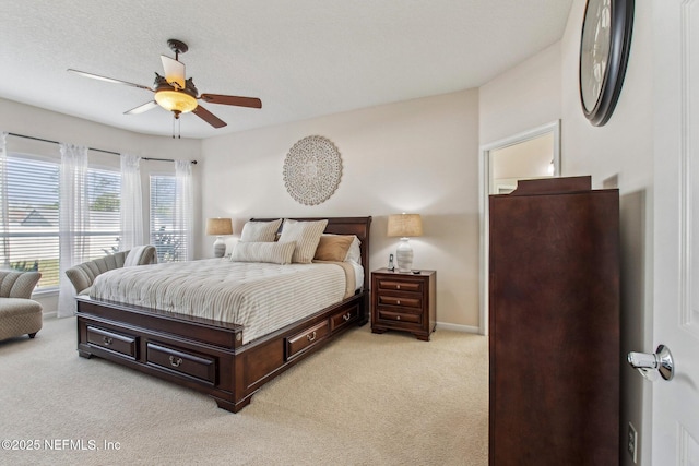 bedroom featuring light carpet, a textured ceiling, a ceiling fan, and baseboards