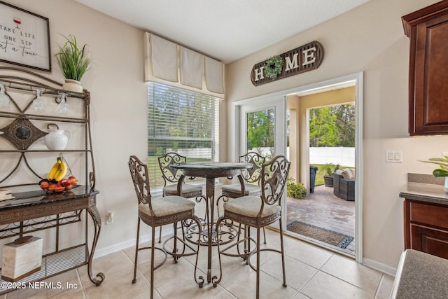 dining room with baseboards and light tile patterned floors