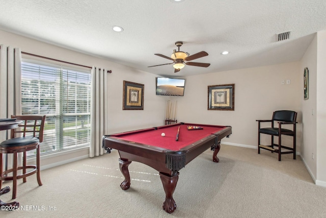 game room with a wealth of natural light, pool table, light colored carpet, and a textured ceiling