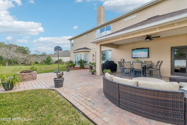 view of patio featuring a ceiling fan, outdoor dining space, an outdoor living space with a fire pit, and a grill