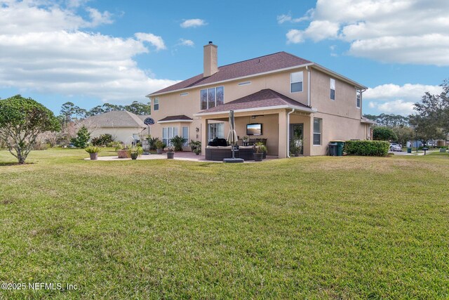 rear view of property with stucco siding, a patio, a chimney, and a lawn