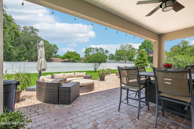 view of patio featuring outdoor dining area, a fenced backyard, ceiling fan, and an outdoor living space