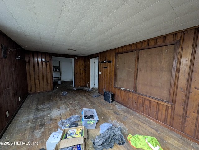 interior space with wooden walls, visible vents, and wood finished floors