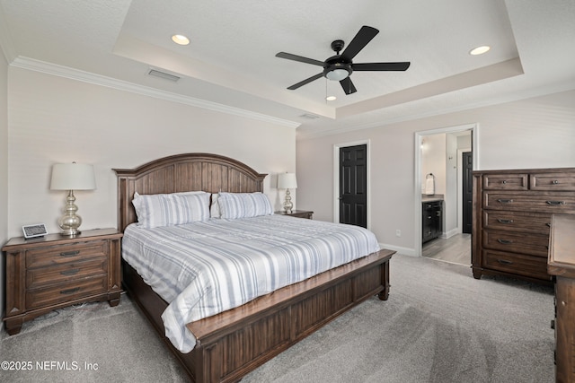 bedroom featuring a tray ceiling, visible vents, and light colored carpet