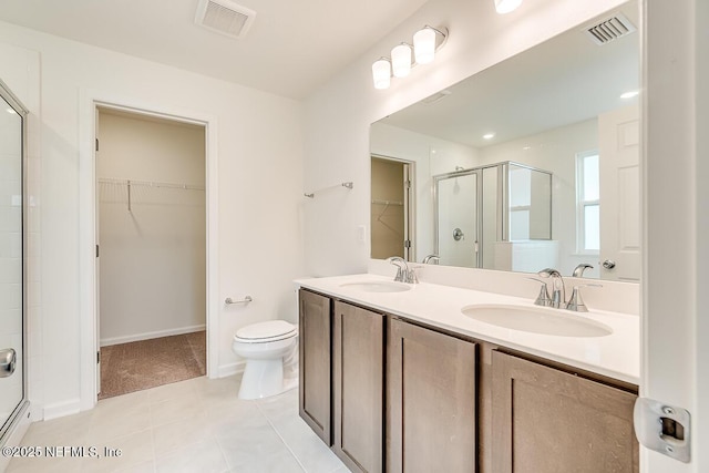 full bath featuring a spacious closet, a sink, visible vents, and a shower stall