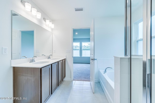 full bathroom with a bath, tile patterned flooring, a sink, and visible vents