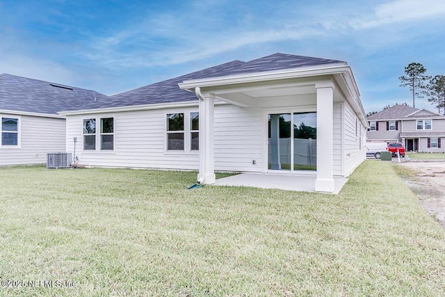 back of house featuring a yard, roof with shingles, a patio area, and cooling unit