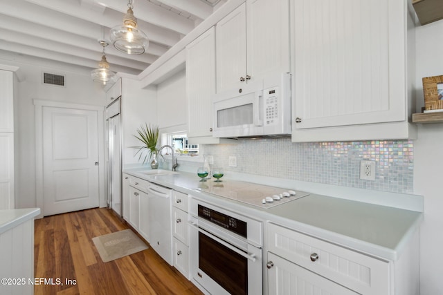 kitchen with white appliances, a sink, visible vents, light countertops, and tasteful backsplash