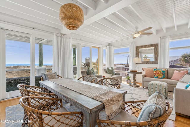 sunroom / solarium with ceiling fan and beamed ceiling