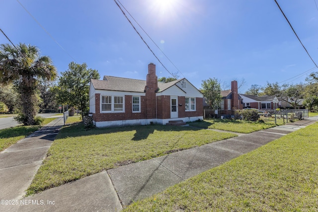 bungalow-style home with brick siding, a chimney, crawl space, fence, and a front lawn