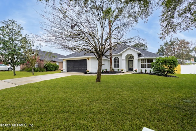 ranch-style house with a garage, fence, driveway, stucco siding, and a front lawn