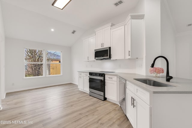 kitchen with stainless steel appliances, a sink, visible vents, and white cabinets