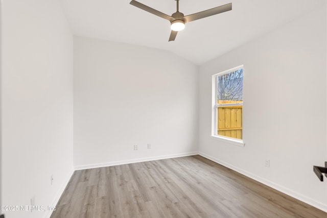 empty room featuring light wood-style floors, vaulted ceiling, baseboards, and a ceiling fan