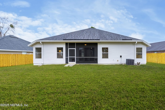 rear view of property featuring a sunroom, a fenced backyard, and a lawn