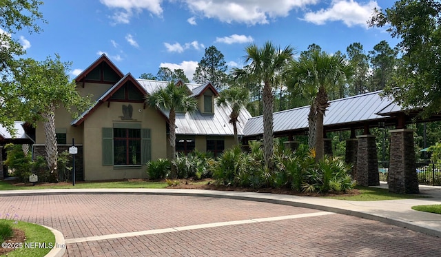 view of front of property featuring a standing seam roof, metal roof, and stucco siding