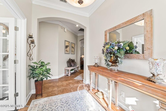 corridor with baseboards, visible vents, arched walkways, and crown molding