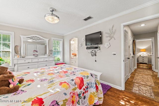 bedroom featuring a textured ceiling, ornamental molding, and wood finished floors