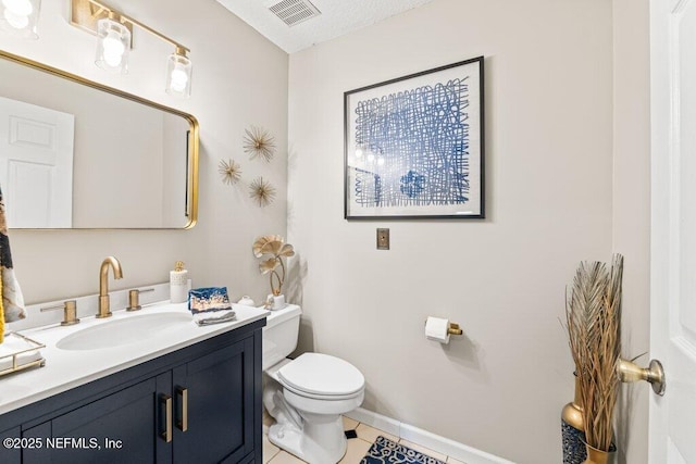 bathroom featuring visible vents, toilet, vanity, baseboards, and tile patterned floors