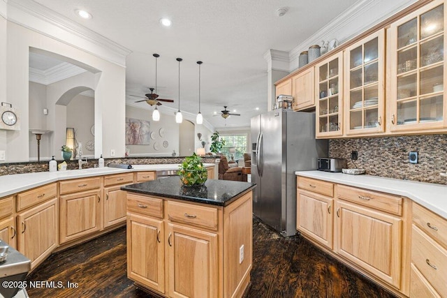 kitchen featuring a center island, backsplash, crown molding, and light brown cabinetry