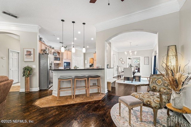 kitchen featuring visible vents, dark countertops, wood finished floors, black microwave, and stainless steel refrigerator with ice dispenser