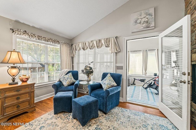 sitting room featuring vaulted ceiling, a textured ceiling, wood finished floors, and baseboards