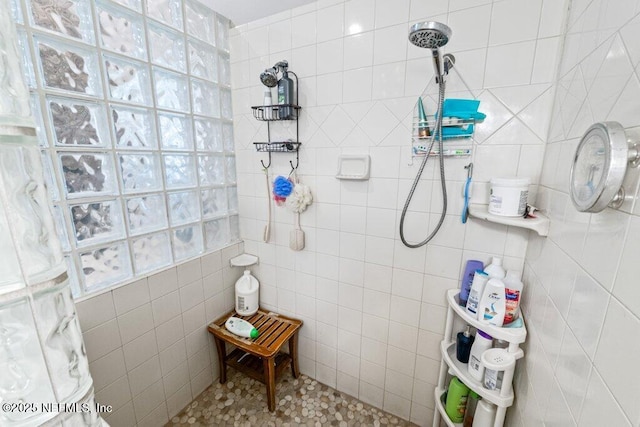 bathroom featuring tile walls and tiled shower