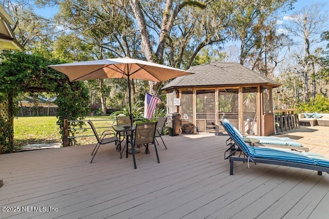 deck featuring outdoor dining space and a sunroom