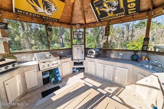 view of patio with exterior kitchen, a sink, grilling area, and a gazebo