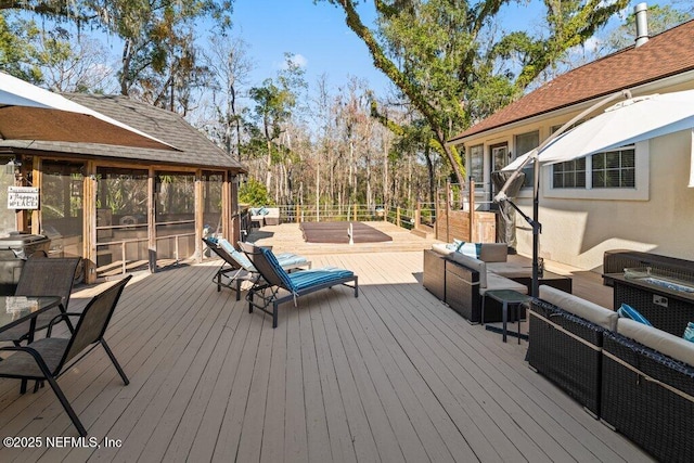 wooden terrace with a sunroom and an outdoor living space