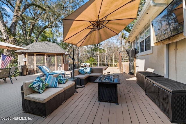 wooden terrace featuring an outdoor living space with a fire pit