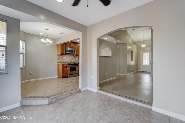 interior space featuring light tile patterned floors, baseboards, visible vents, ceiling fan with notable chandelier, and recessed lighting