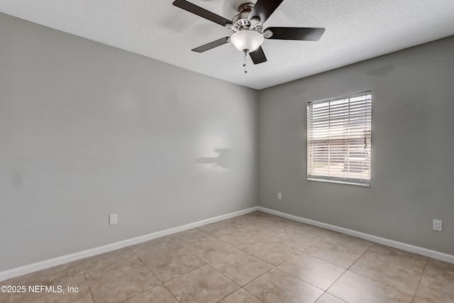 unfurnished room featuring a ceiling fan, a textured ceiling, baseboards, and light tile patterned floors