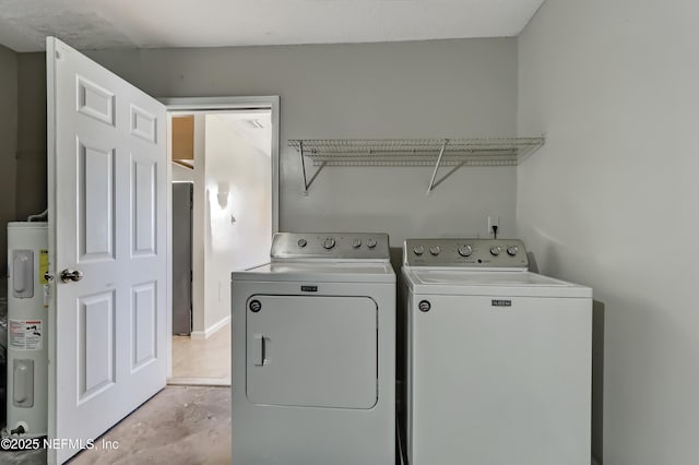 laundry room with laundry area, water heater, and washer and clothes dryer