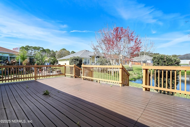 wooden deck with a residential view and a water view