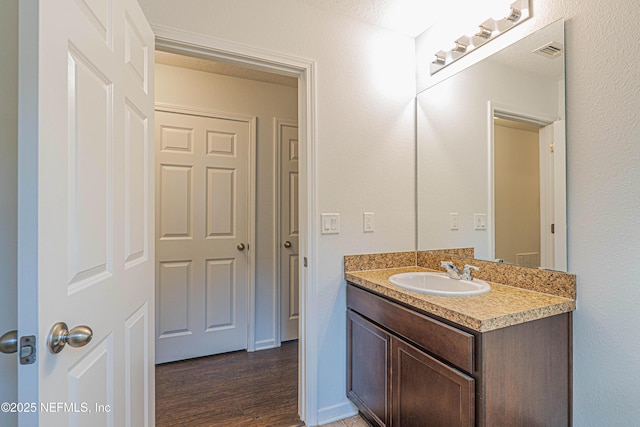 bathroom featuring visible vents, vanity, and wood finished floors