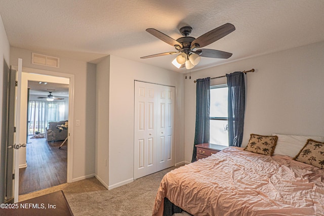 bedroom featuring a textured ceiling, a closet, carpet flooring, and visible vents