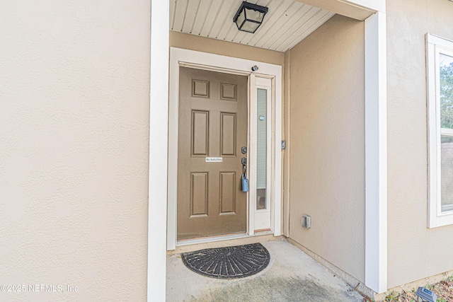 view of exterior entry with stucco siding