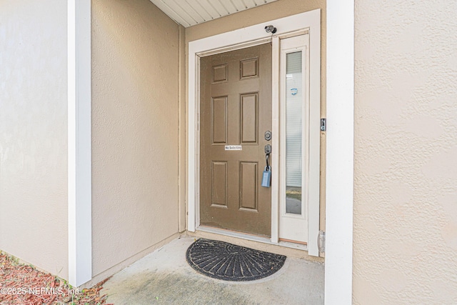 doorway to property with stucco siding