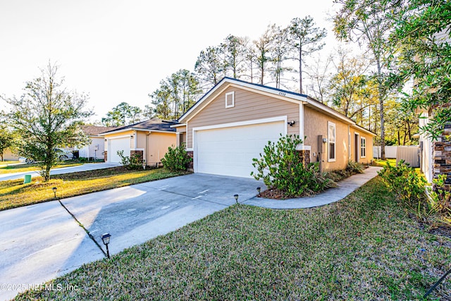 view of front of house featuring a garage, concrete driveway, stucco siding, fence, and a front yard