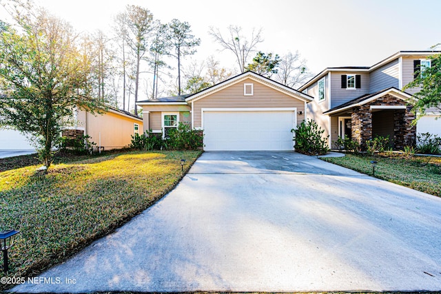 view of front facade featuring driveway, stone siding, an attached garage, and a front yard