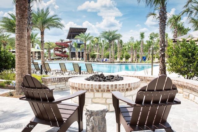 community pool with a fire pit and a patio